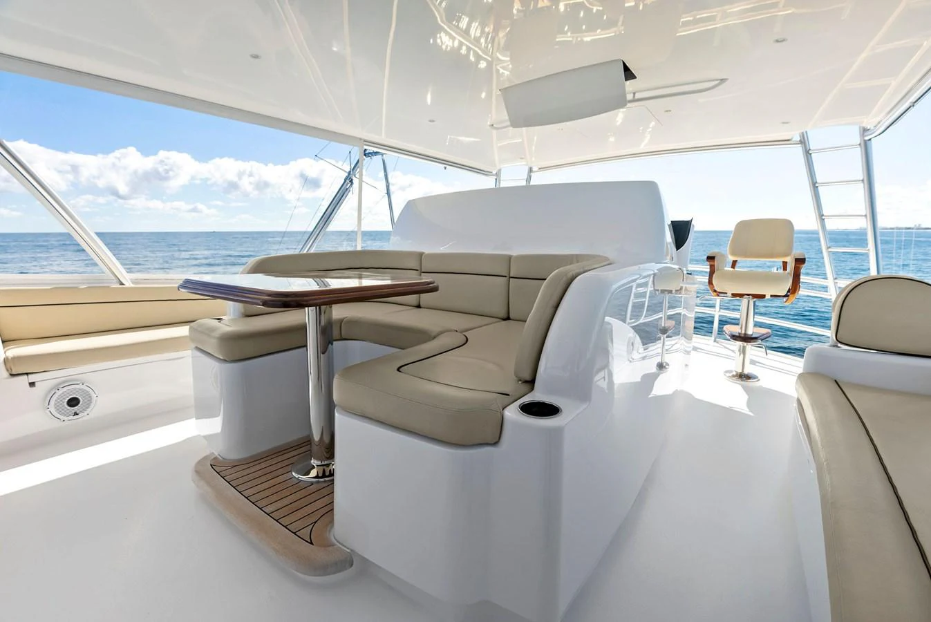 The flybridge features a comfortable seating area with a table, offering stunning ocean views. aboard CATCH 23 Yacht for Sale