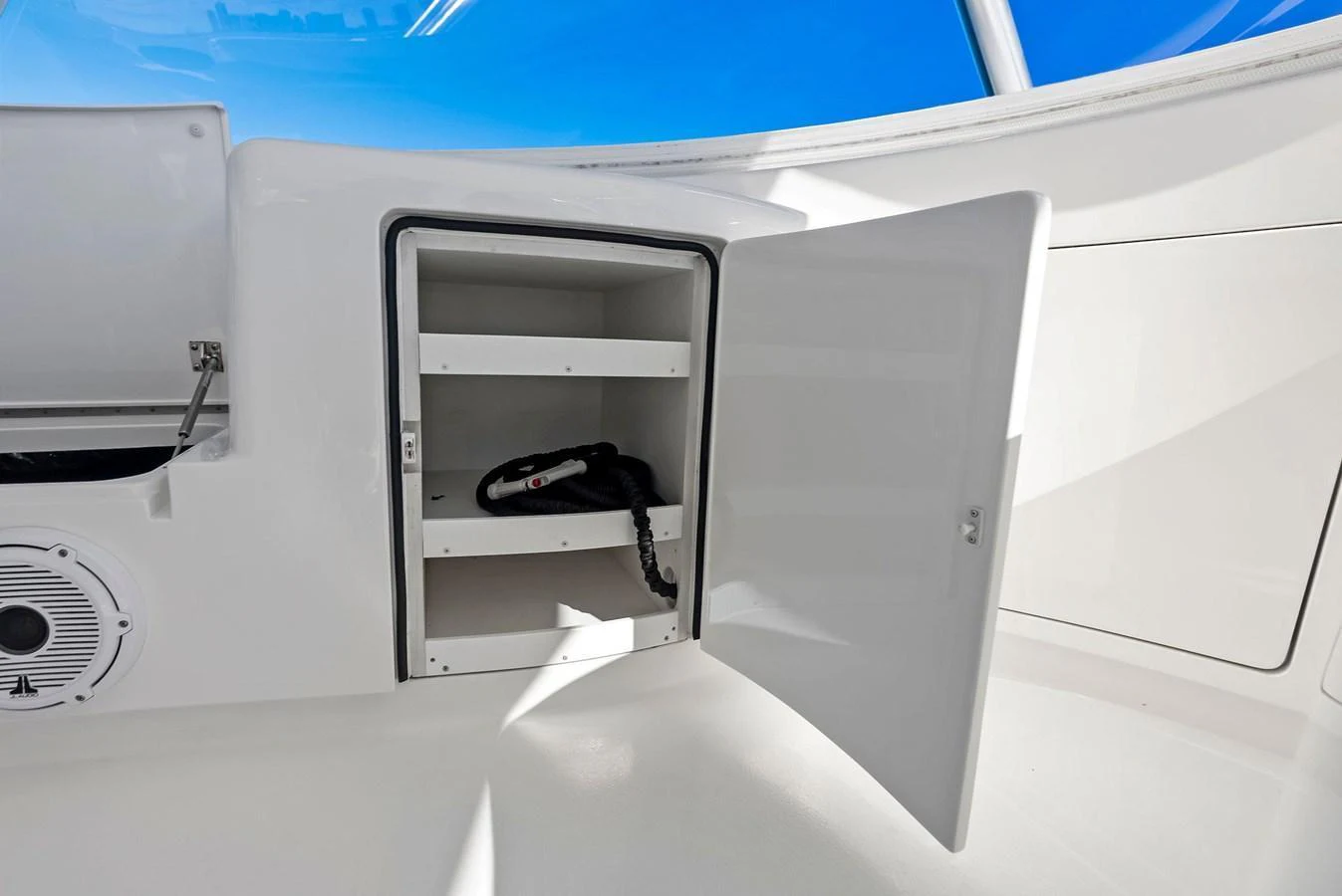 A close-up view of a storage compartment with a handheld radio inside. aboard CATCH 23 Yacht for Sale