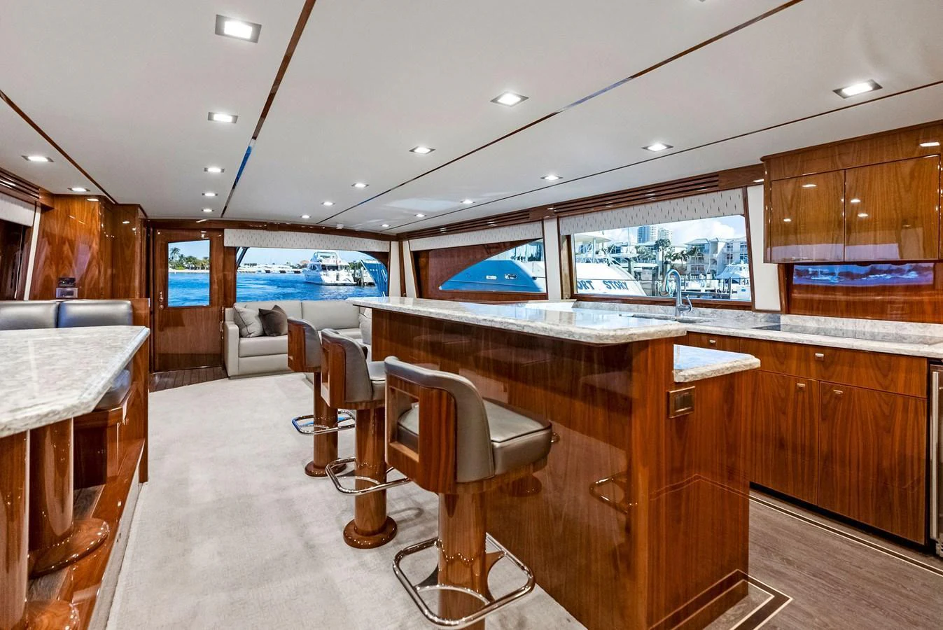 The yacht's salon features luxurious seating, a bar area, and large windows offering stunning views. aboard CATCH 23 Yacht for Sale