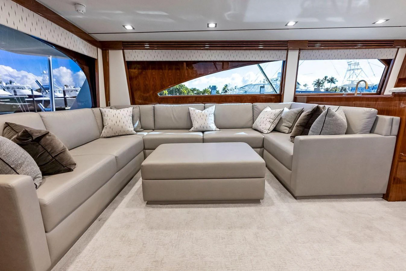 The salon features a spacious and elegant seating area with plush cushions and a large ottoman. aboard CATCH 23 Yacht for Sale