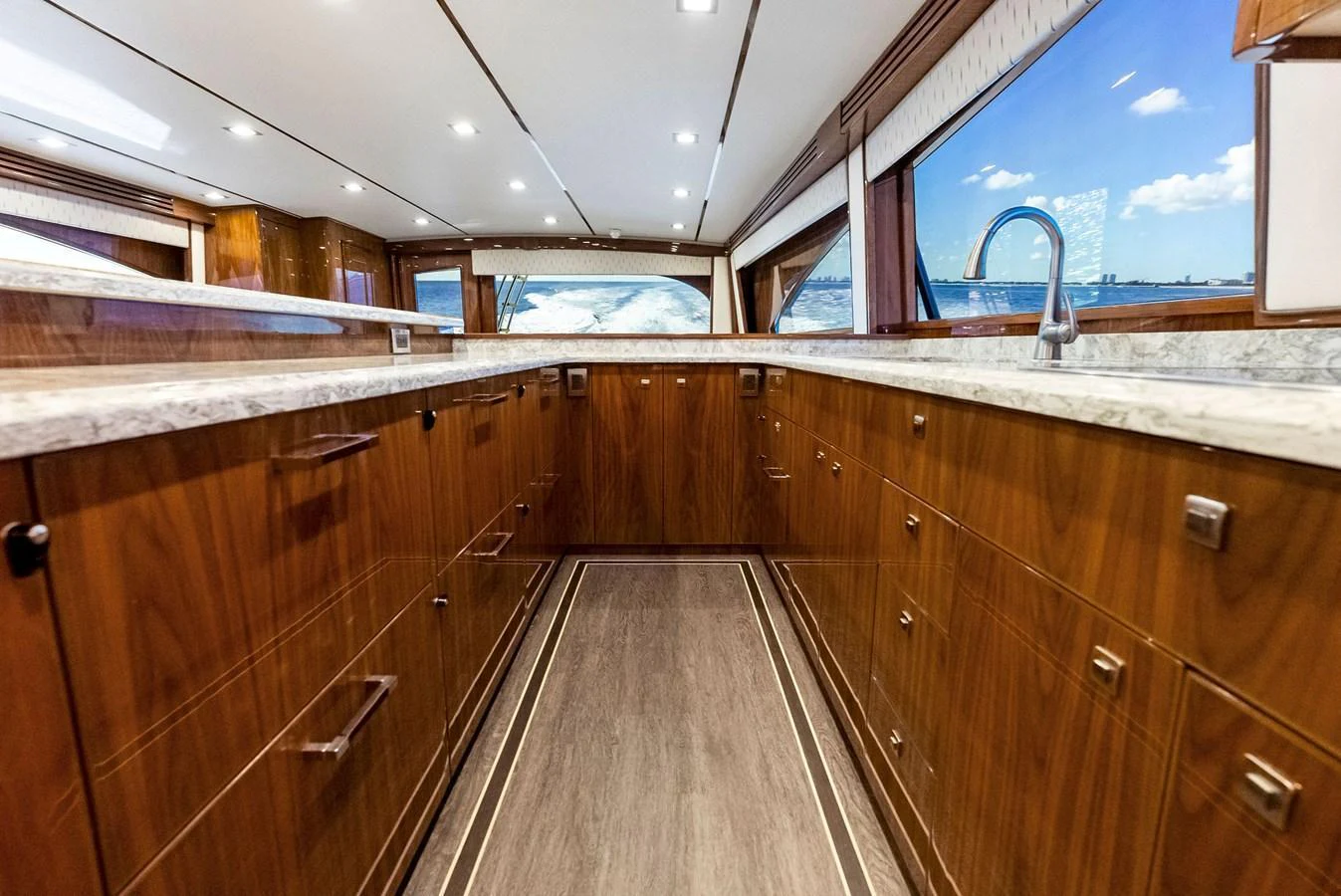 The galley features elegant wood cabinetry and a sleek marble countertop, with large windows offering stunning ocean views. aboard CATCH 23 Yacht for Sale