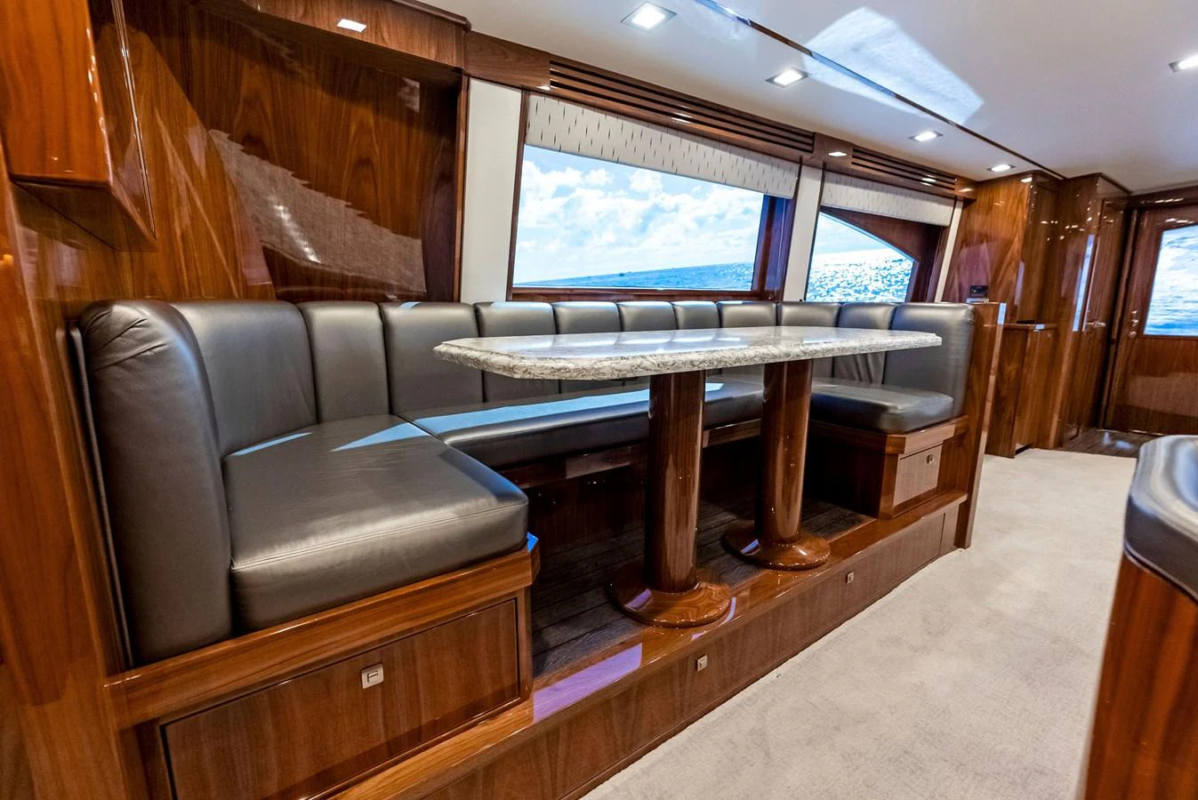 The yacht's dining area features a luxurious setting with plush seating and a polished wooden table. aboard CATCH 23 Yacht for Sale