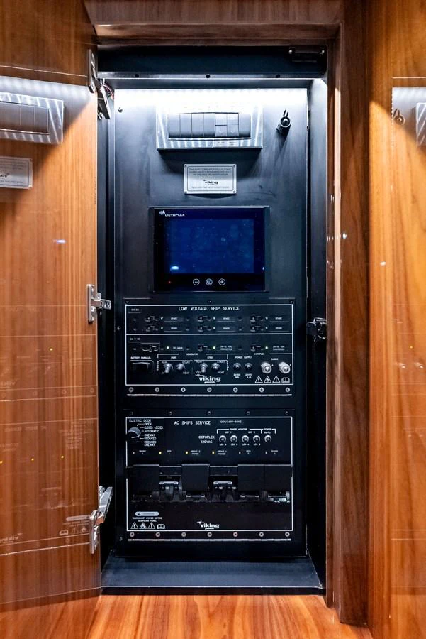 The image showcases the yacht's advanced electrical control panel, neatly organized within a wooden cabinet. aboard CATCH 23 Yacht for Sale