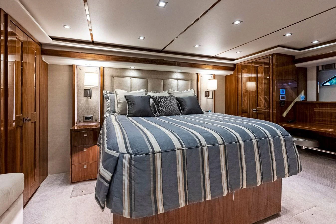 The master stateroom features a spacious bed with elegant bedding and ample wood cabinetry. aboard CATCH 23 Yacht for Sale