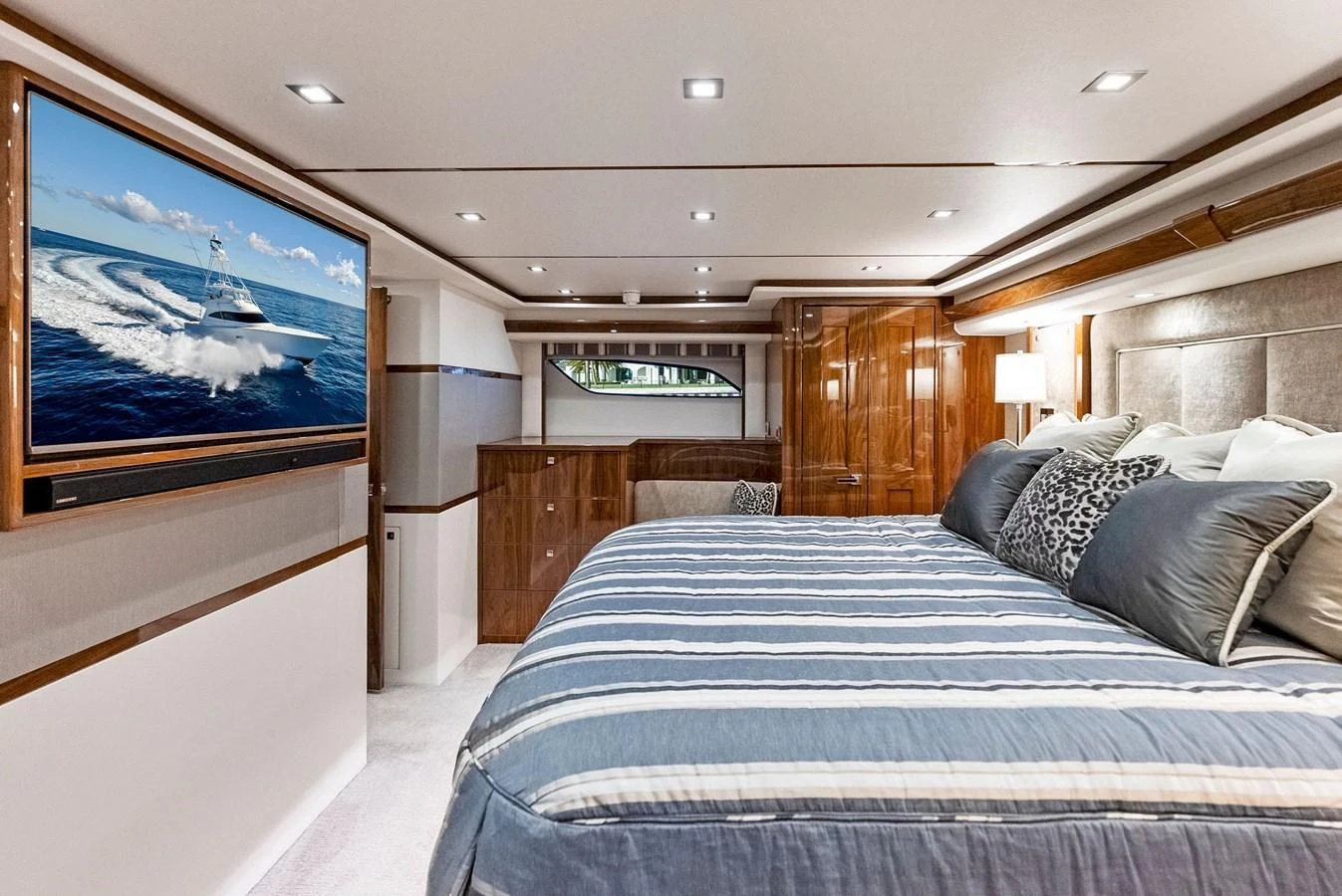 The luxurious stateroom features a large bed, elegant wood finishes, and a flat-screen TV. aboard CATCH 23 Yacht for Sale