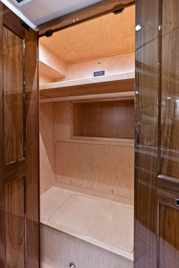 A spacious wooden closet with shelves and storage compartments. aboard CATCH 23 Yacht for Sale