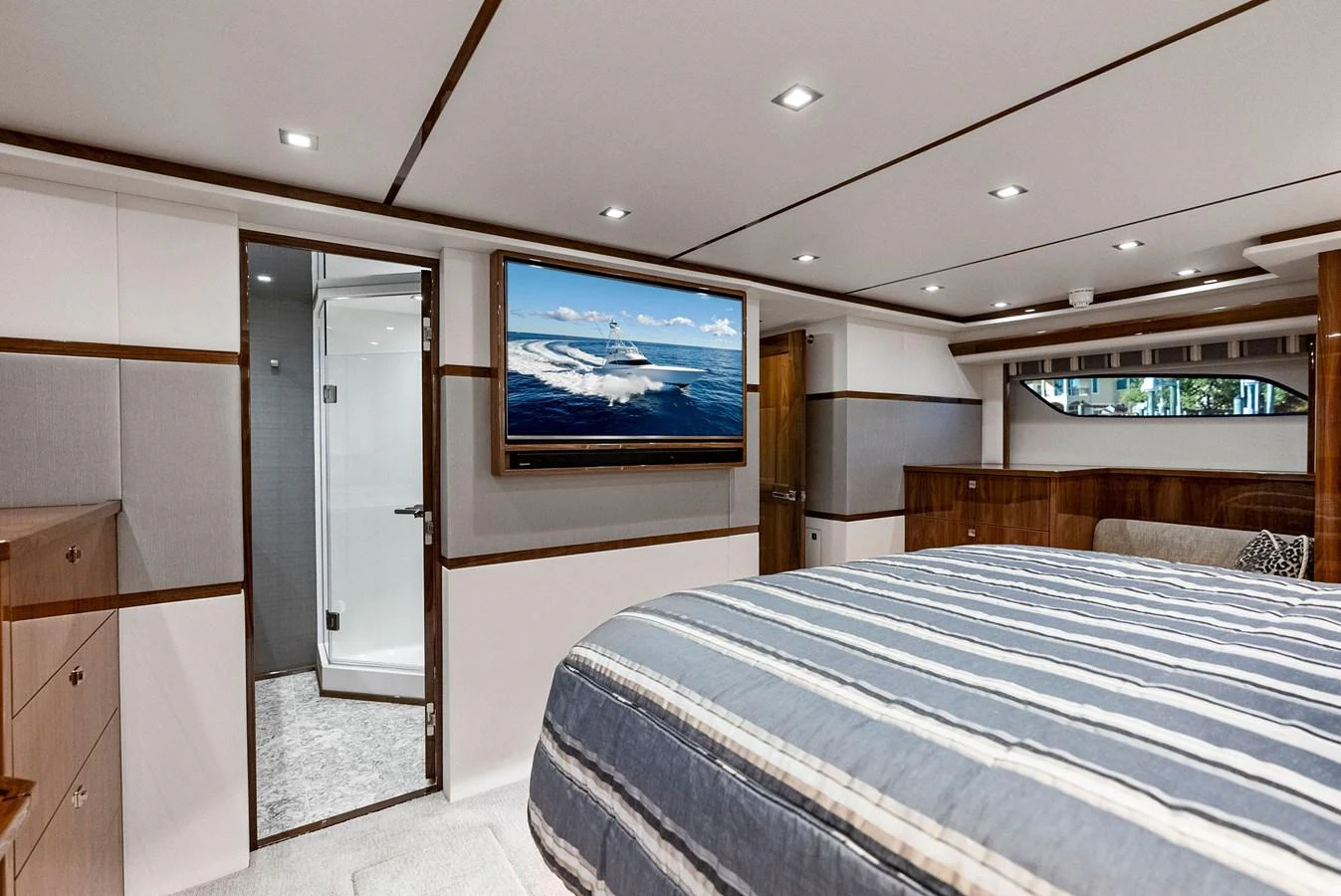 A spacious stateroom featuring a large bed, modern decor, and a flat-screen TV. aboard CATCH 23 Yacht for Sale