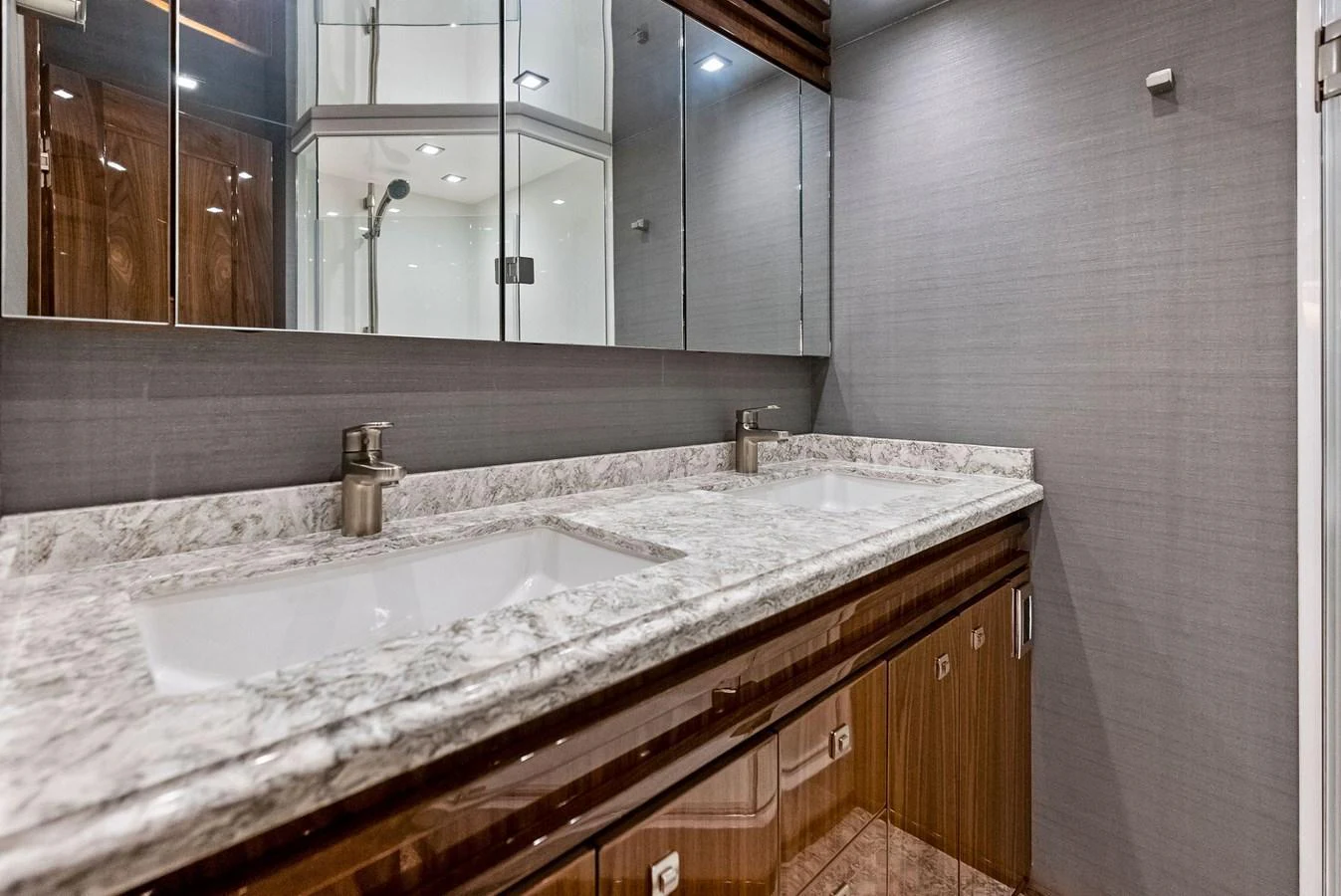 The yacht's bathroom features a sleek, modern design with a double sink and marble countertop. aboard CATCH 23 Yacht for Sale