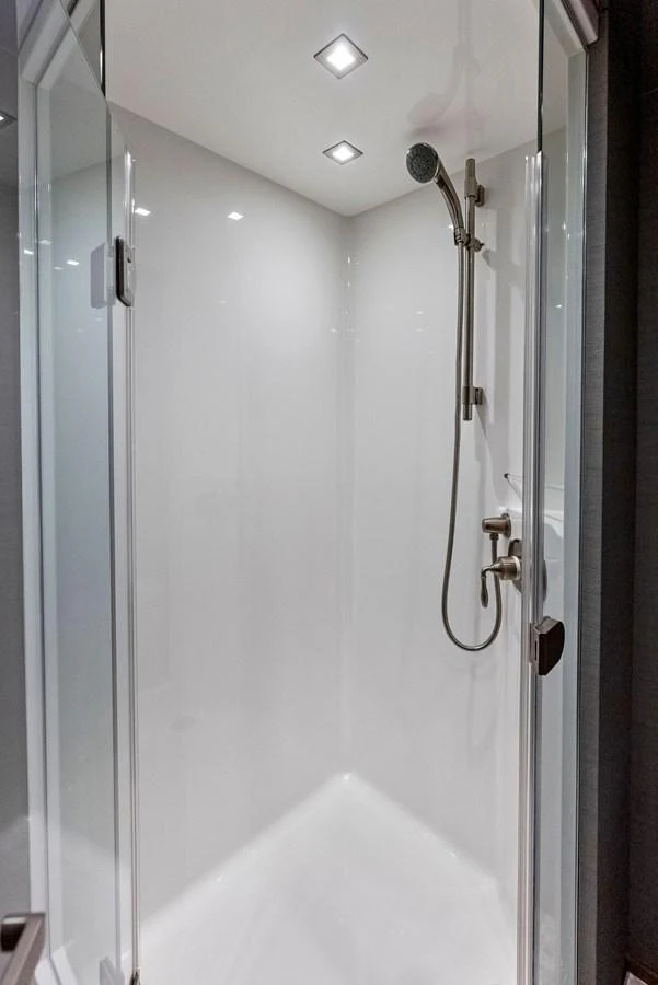 A sleek and modern shower area with a glass door and chrome fixtures. aboard CATCH 23 Yacht for Sale