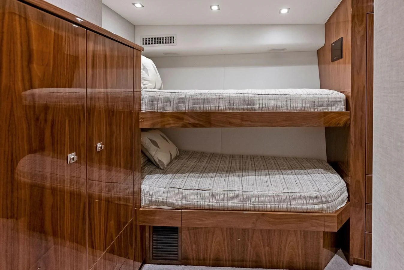 The cozy bunk cabin features sleek wood finishes and comfortable bedding. aboard CATCH 23 Yacht for Sale
