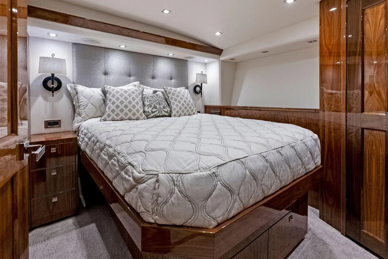 The stateroom features a luxurious bed with elegant wood finishes and modern lighting. aboard CATCH 23 Yacht for Sale