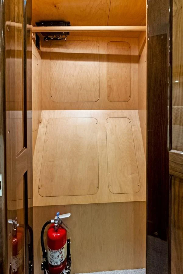 A small storage area with wooden panels and a fire extinguisher. aboard CATCH 23 Yacht for Sale