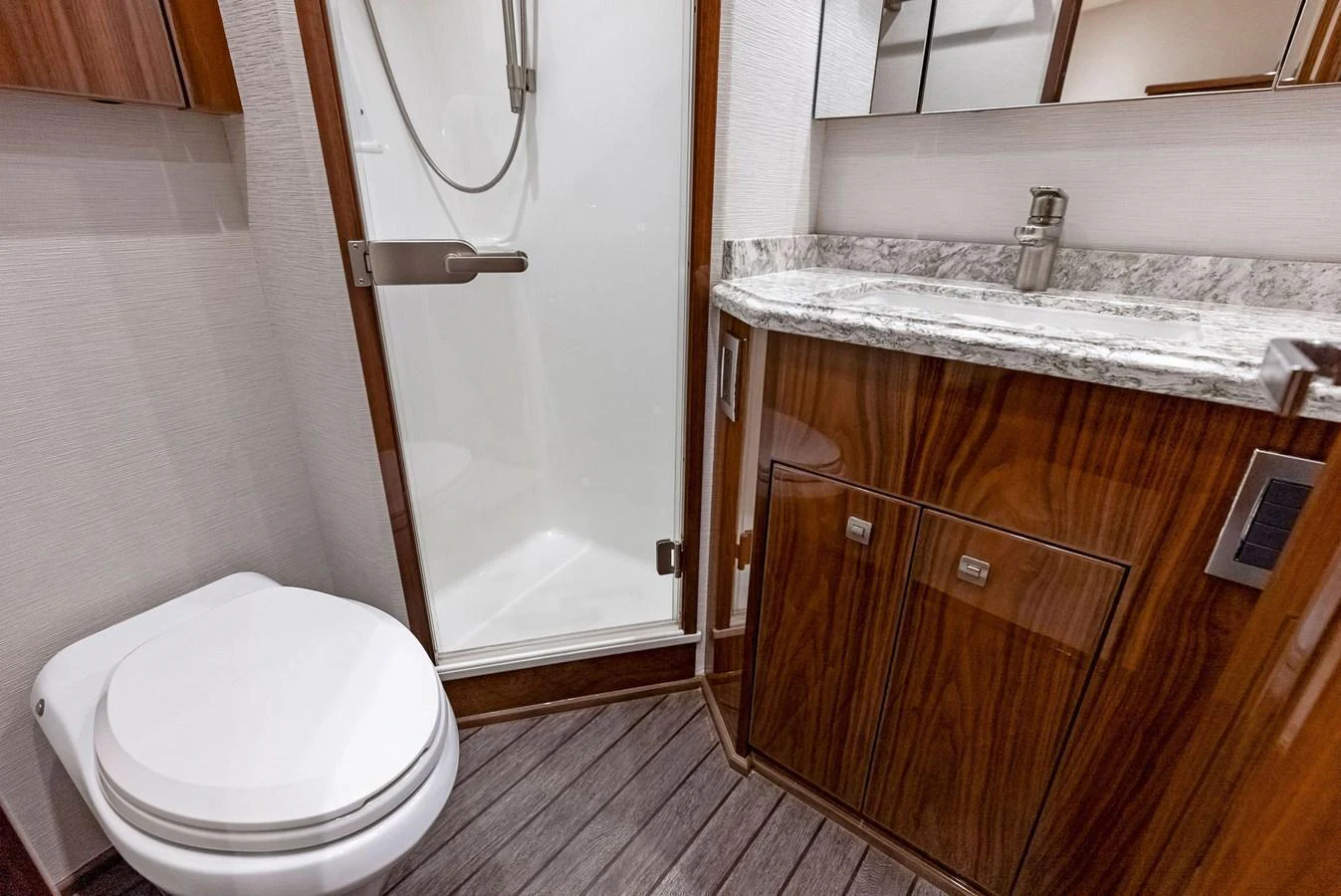 The yacht's head features a sleek design with a modern shower and elegant wooden cabinetry. aboard CATCH 23 Yacht for Sale