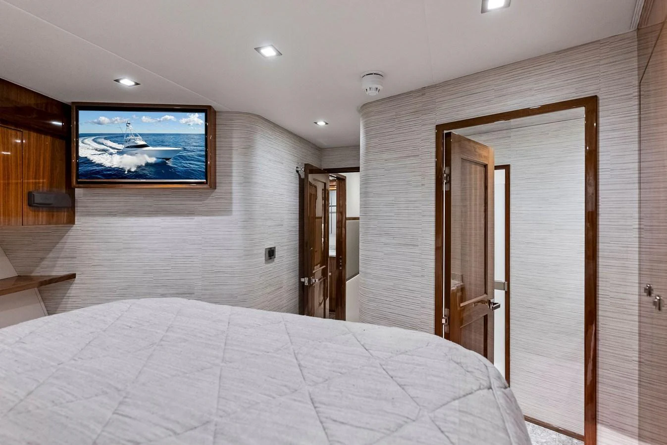 The stateroom features a comfortable bed, modern lighting, and a mounted television. aboard CATCH 23 Yacht for Sale