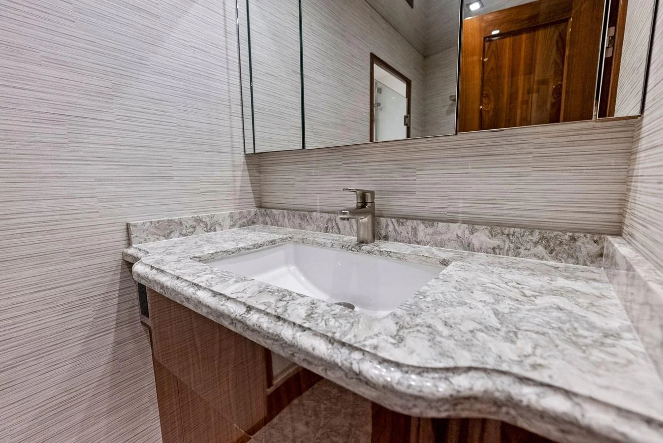 The yacht's bathroom features a sleek marble countertop and modern fixtures. aboard CATCH 23 Yacht for Sale