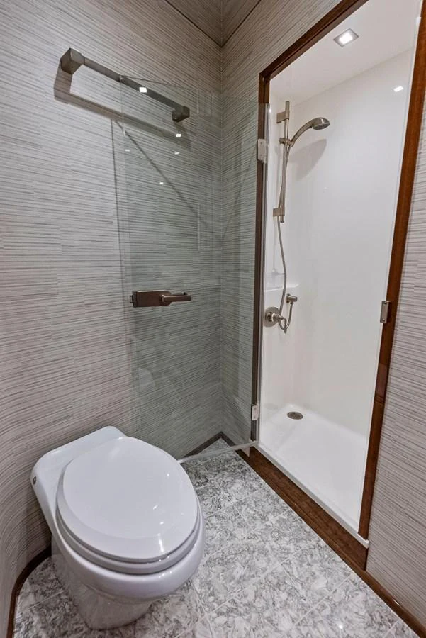 A modern yacht bathroom featuring a sleek shower and a compact toilet. aboard CATCH 23 Yacht for Sale
