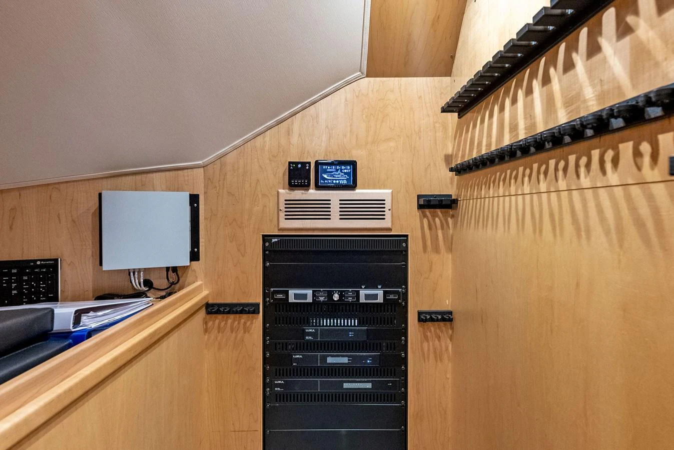 The image showcases the yacht's well-organized electronics room with various equipment and control panels. aboard CATCH 23 Yacht for Sale