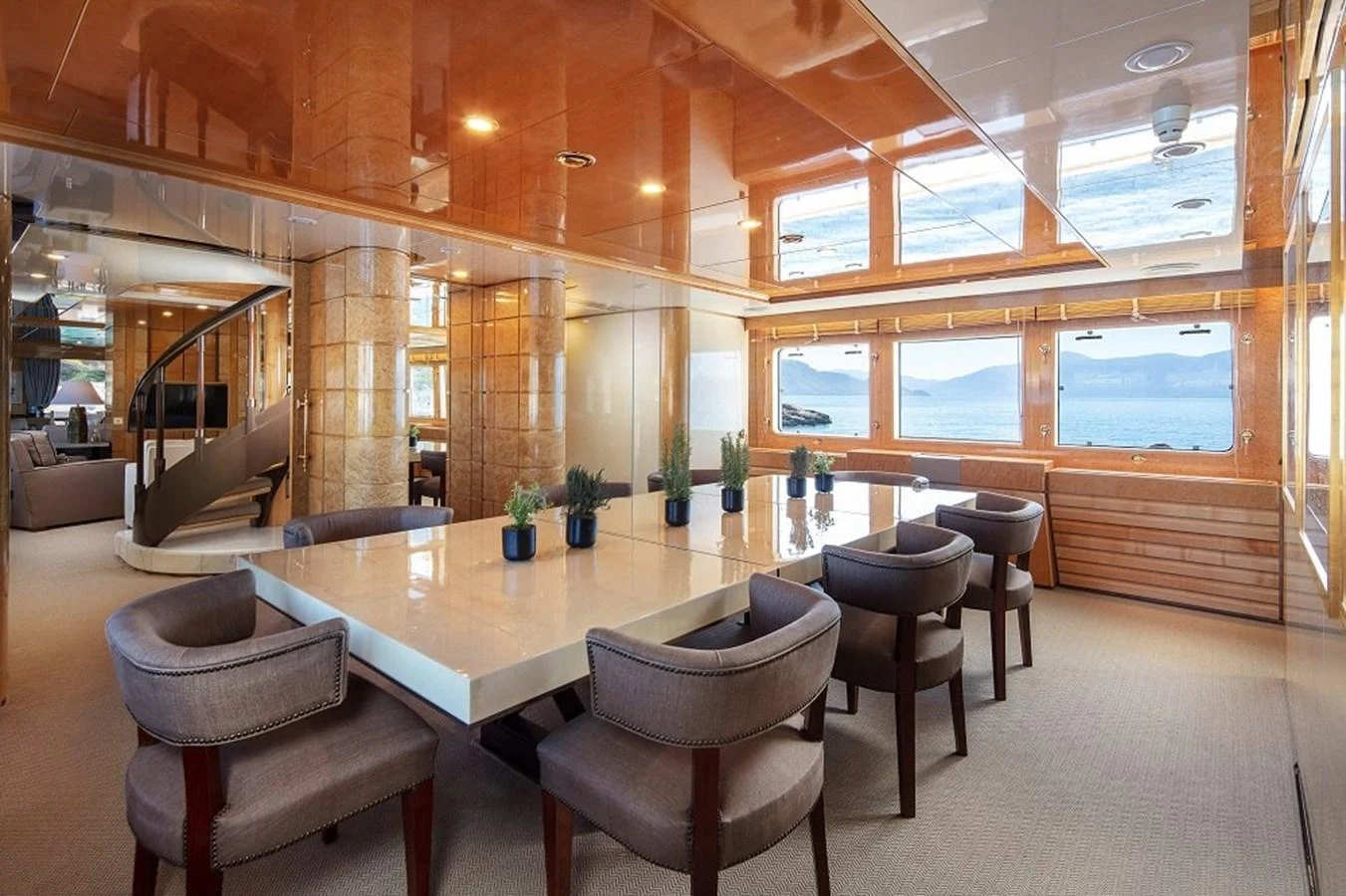 The yacht's dining area features a large table with plush seating and panoramic windows offering stunning sea views. aboard KASSANDRA Yacht for Sale