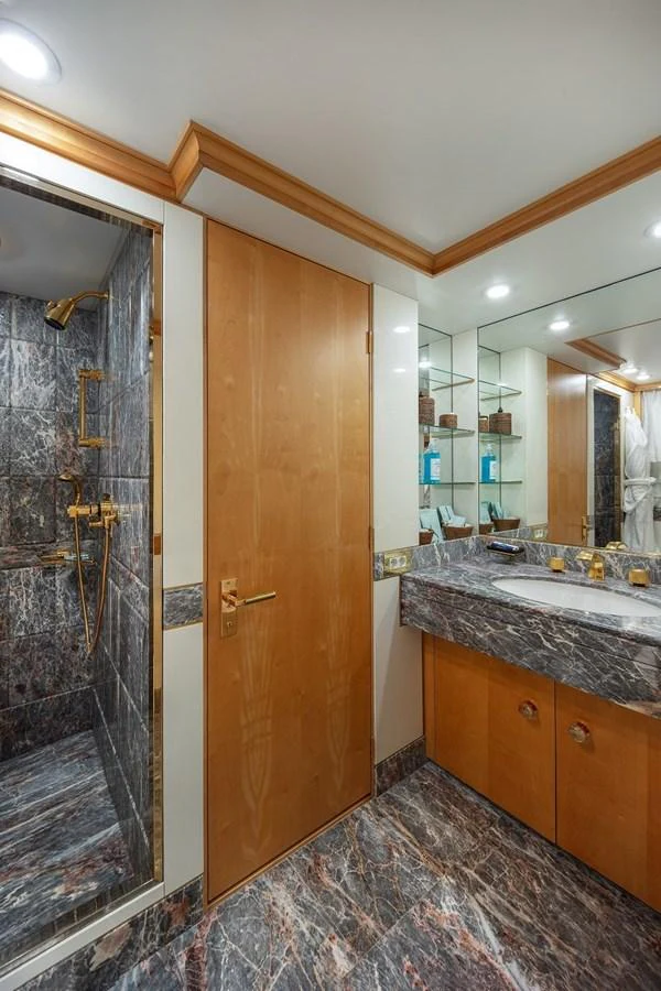 The yacht's bathroom features luxurious marble surfaces and elegant wooden cabinetry. aboard KASSANDRA Yacht for Sale