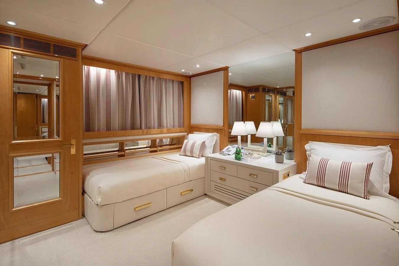 The guest stateroom features twin beds, elegant wood finishes, and soft lighting for a cozy ambiance. aboard KASSANDRA Yacht for Sale