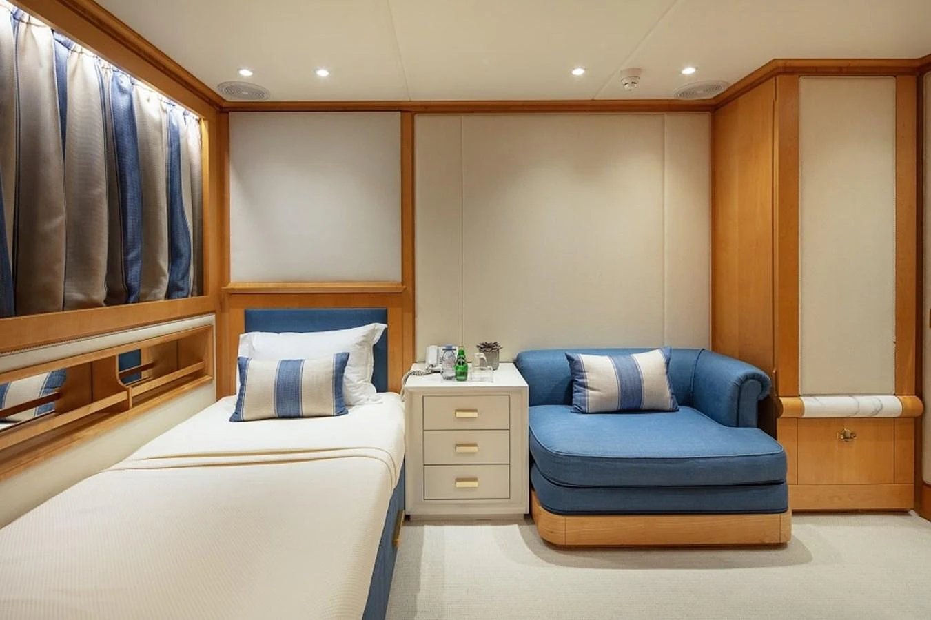 A cozy guest stateroom featuring a single bed and a comfortable seating area. aboard KASSANDRA Yacht for Sale