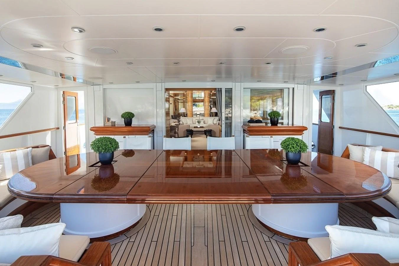 The aft deck features a spacious dining area with a polished wooden table and comfortable seating. aboard KASSANDRA Yacht for Sale