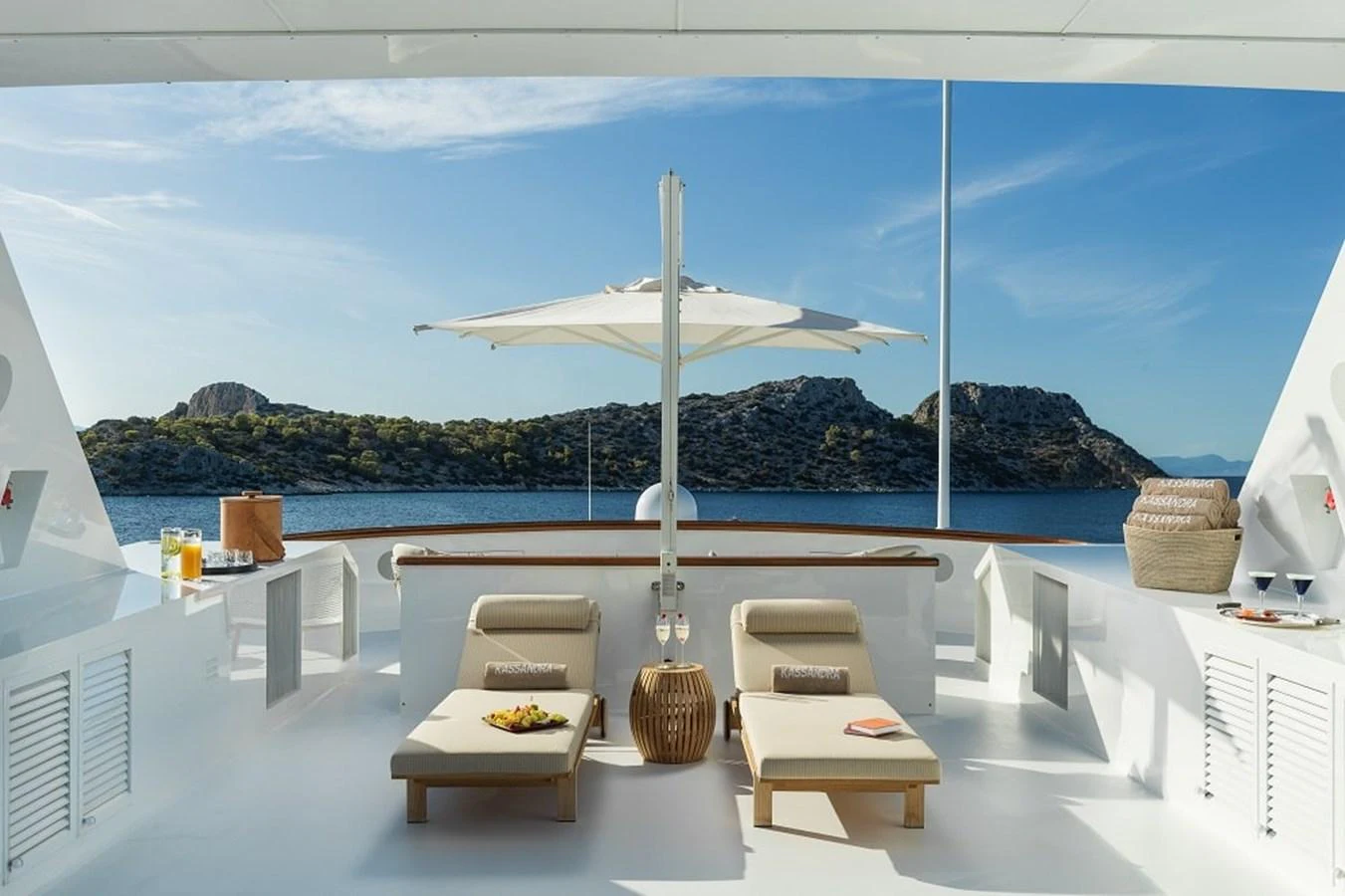 The sundeck offers a serene lounging area with comfortable sunbeds and a stunning view of the water and surrounding landscape. aboard KASSANDRA Yacht for Sale