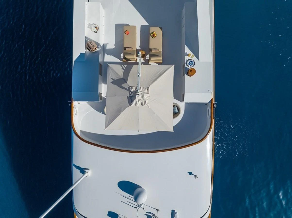 The sundeck offers a serene space with sun loungers and an umbrella, perfect for relaxation. aboard KASSANDRA Yacht for Sale