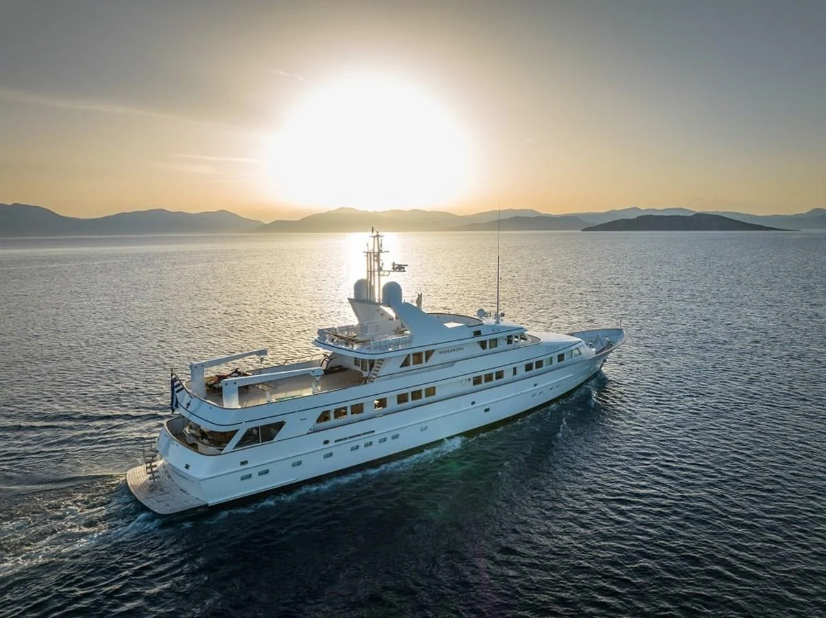 A stunning yacht cruises through serene waters at sunset, showcasing its elegant design and luxurious features. aboard KASSANDRA Yacht for Sale
