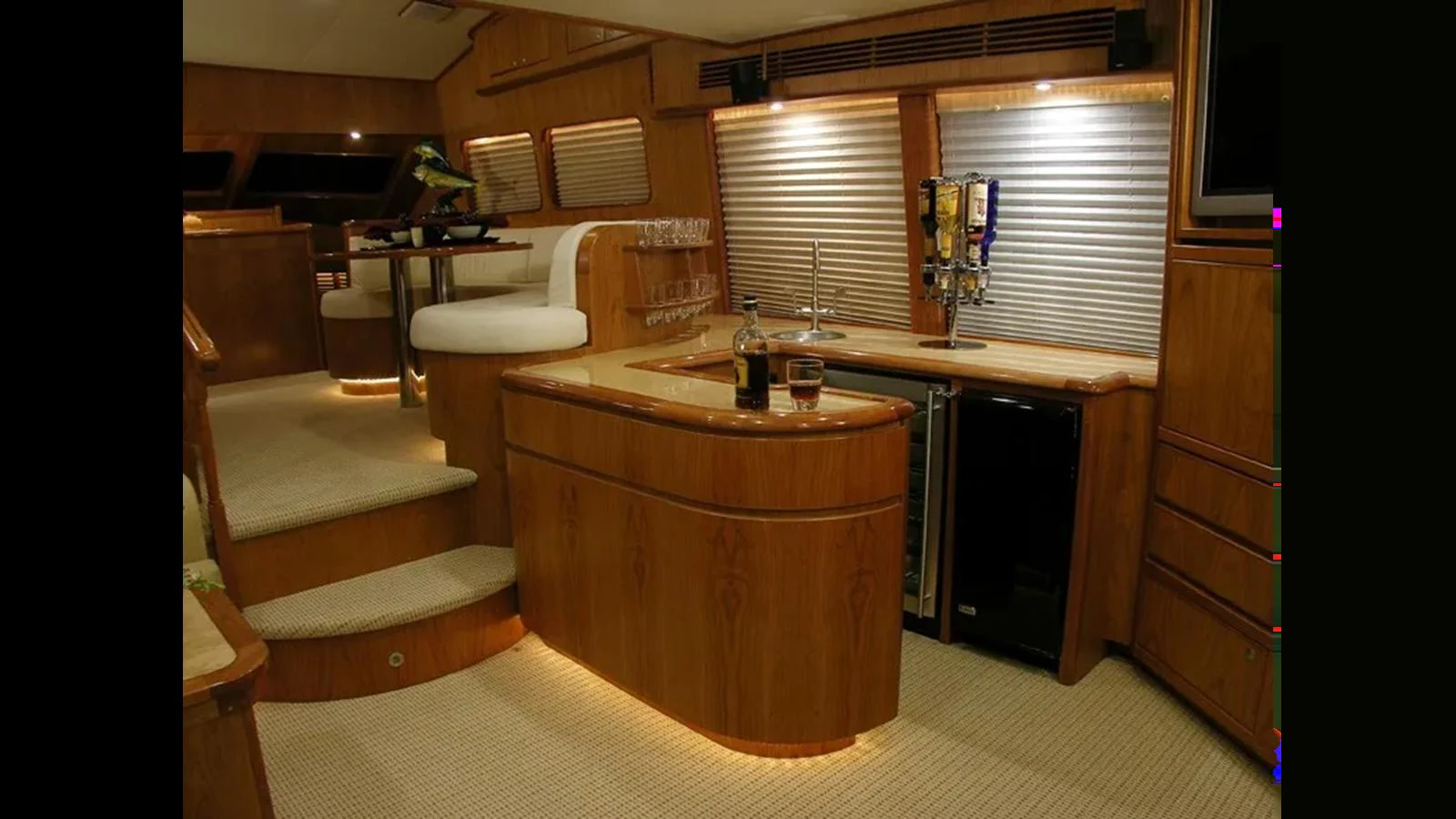 The yacht's galley features a cozy and well-lit space with wooden cabinetry and modern appliances. aboard MIKELSON 75 SPORTFISHER Yacht for Sale