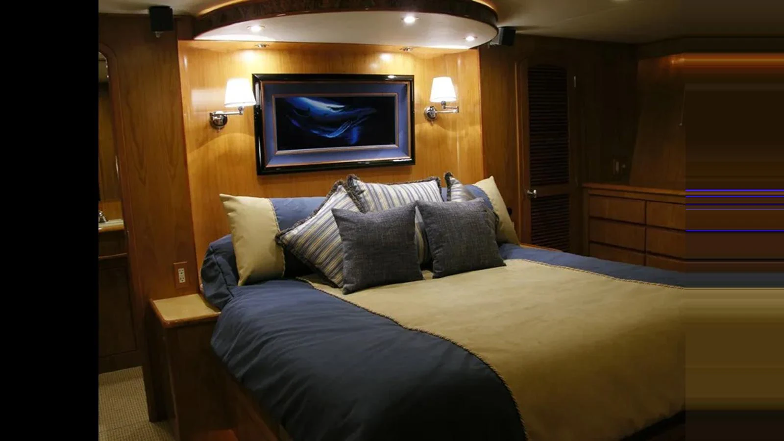 The master stateroom features a luxurious bed with elegant bedding and warm lighting. aboard MIKELSON 75 SPORTFISHER Yacht for Sale