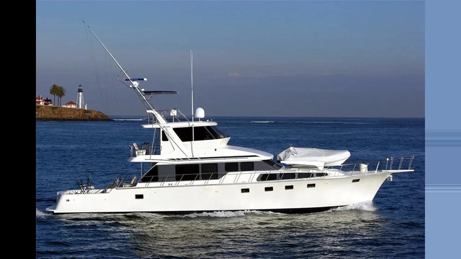A sleek and elegant yacht cruises smoothly on the water under a clear sky. aboard MIKELSON 75 SPORTFISHER Yacht for Sale