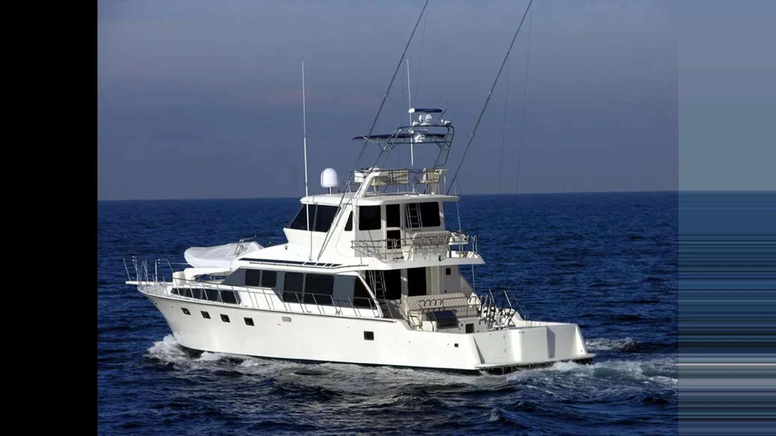 A sleek yacht cruises smoothly on the open sea, showcasing its elegant design and spacious decks. aboard MIKELSON 75 SPORTFISHER Yacht for Sale