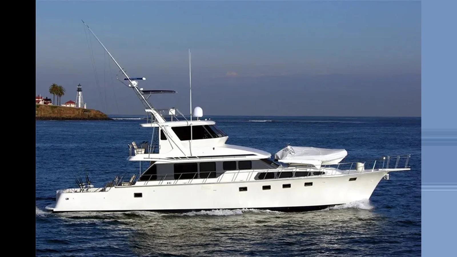 A sleek yacht cruises smoothly on the open water under a clear sky. aboard MIKELSON 75 SPORTFISHER Yacht for Sale