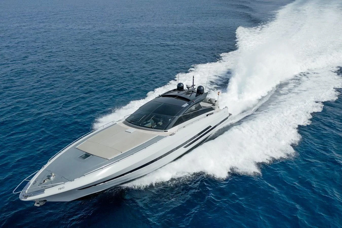 A sleek yacht glides swiftly across the open sea, leaving a trail of white foam in its wake. aboard BAIA 70 Yacht for Sale