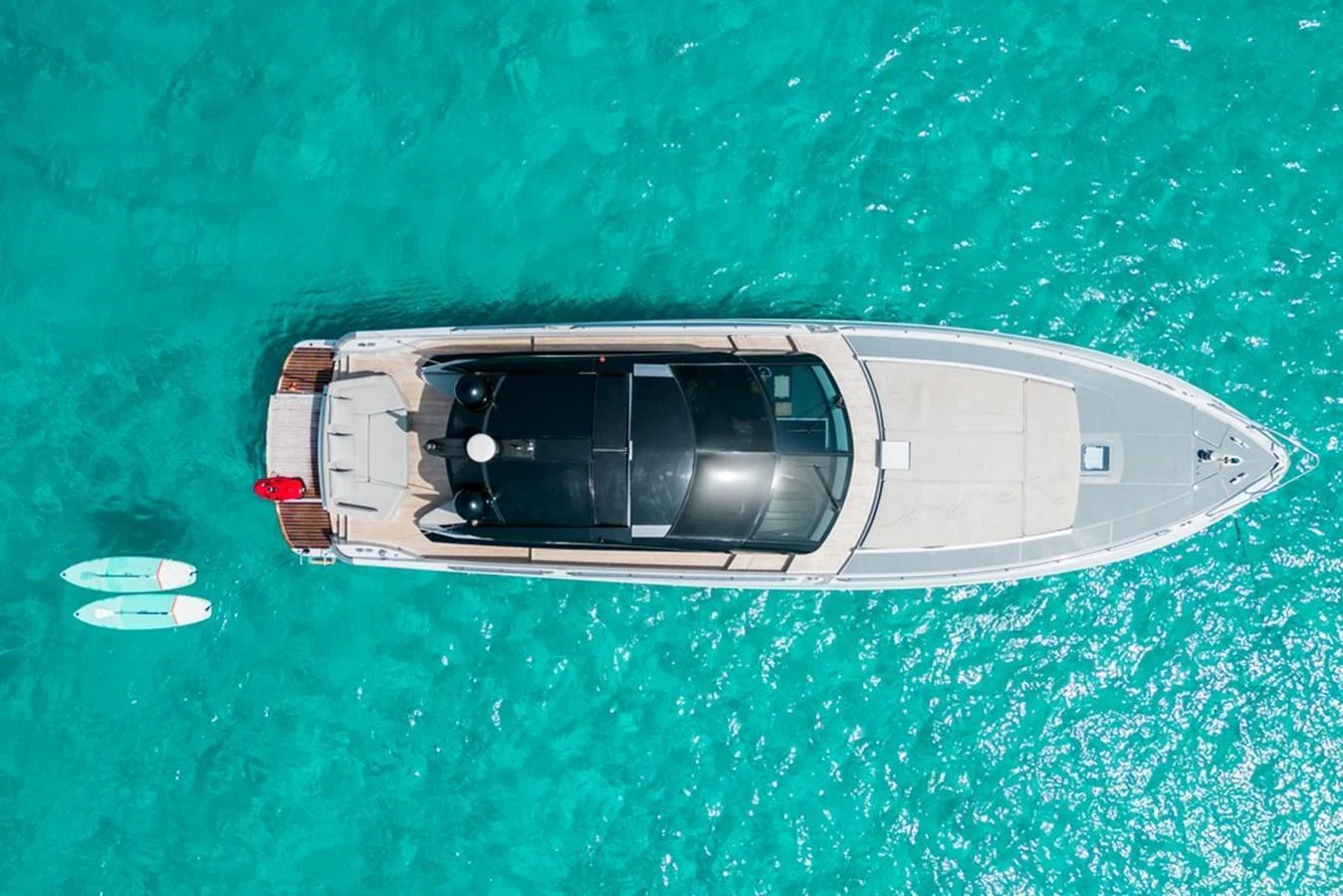 An aerial view of a sleek yacht cruising through crystal-clear turquoise waters. aboard BAIA 70 Yacht for Sale
