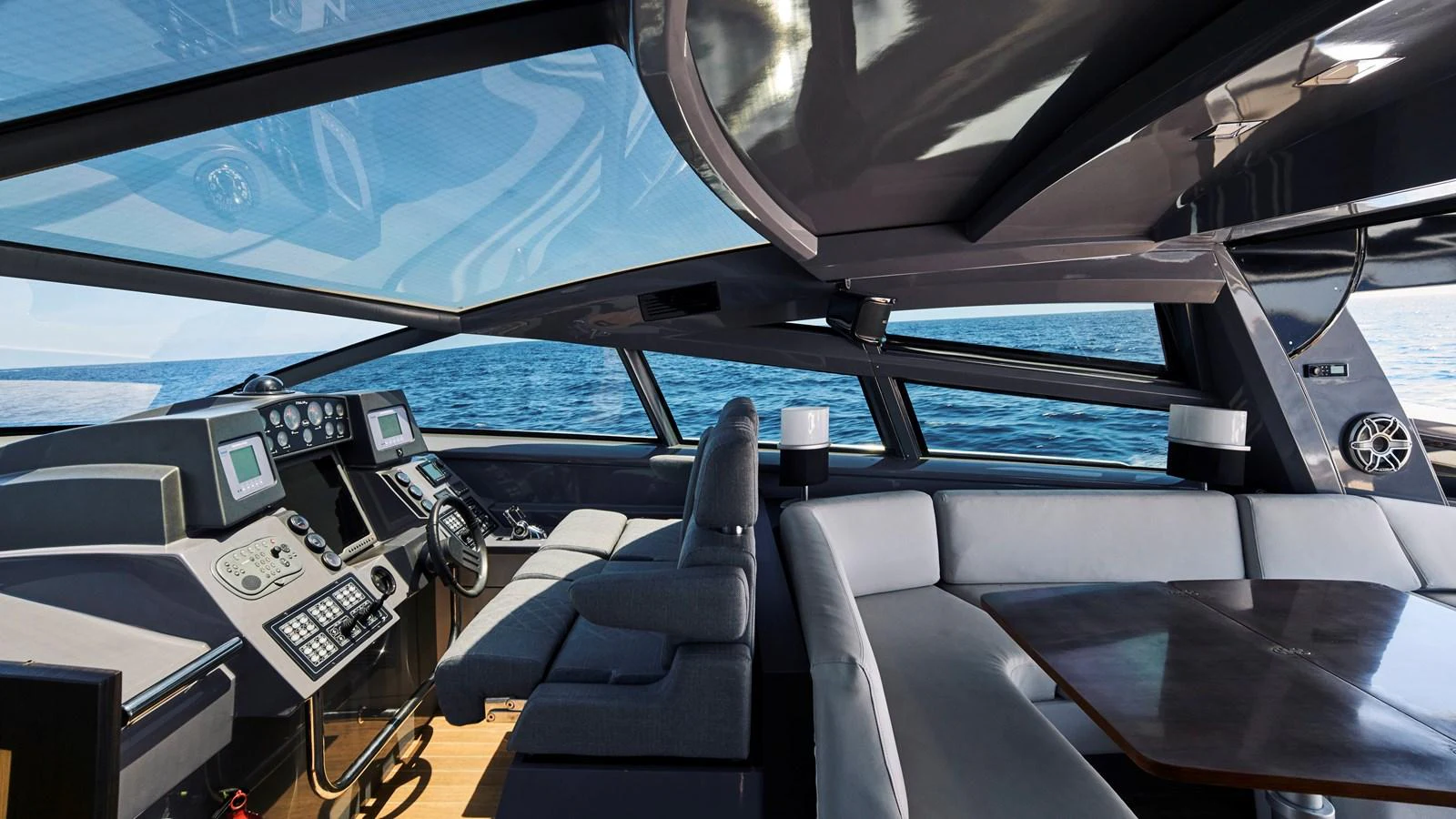 The yacht's helm station features modern navigation equipment and a spacious seating area with panoramic ocean views. aboard BAIA 70 Yacht for Sale