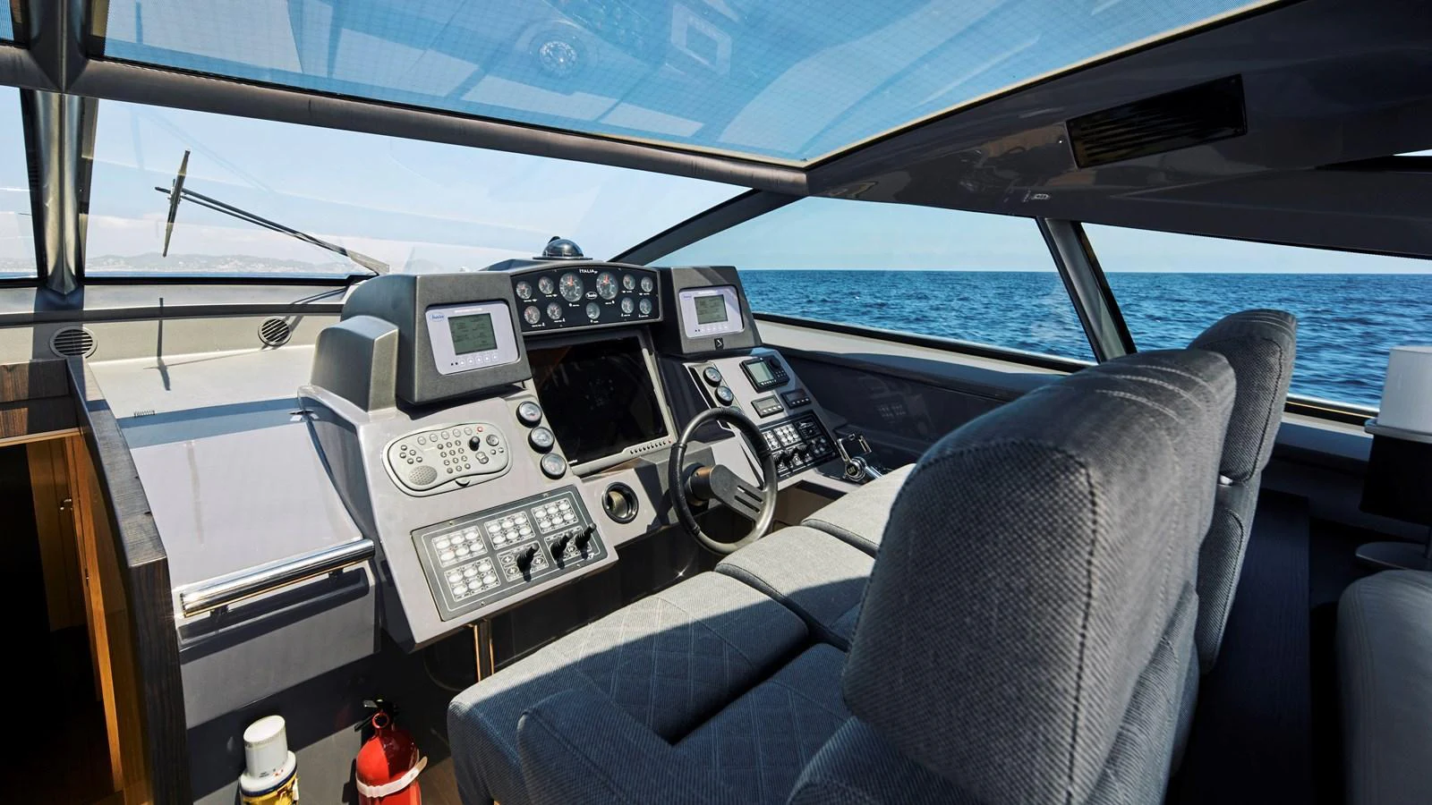 The helm station offers a commanding view with state-of-the-art navigation equipment and luxurious seating. aboard BAIA 70 Yacht for Sale