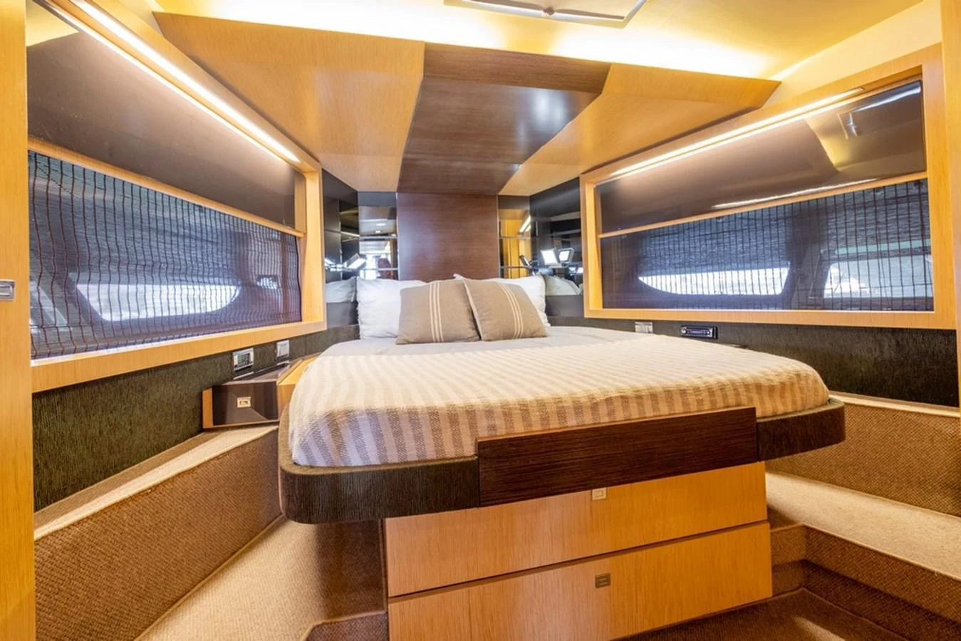 The stateroom features a comfortable bed with ample natural light from large windows. aboard BAIA 70 Yacht for Sale
