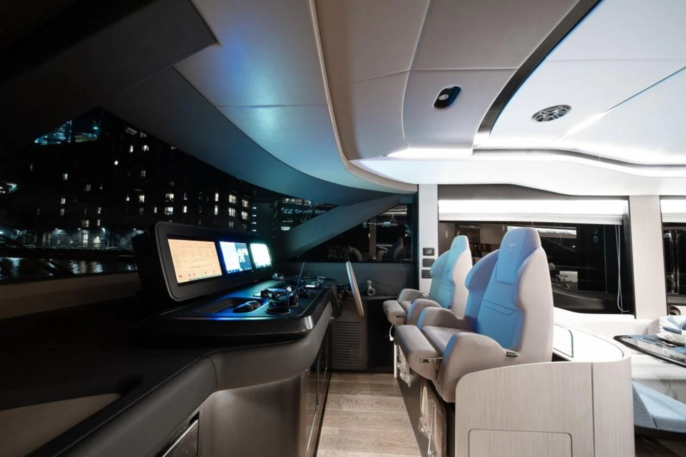 The yacht's helm features modern navigation equipment and luxurious seating, illuminated by ambient lighting. aboard TOPAZ Yacht for Sale