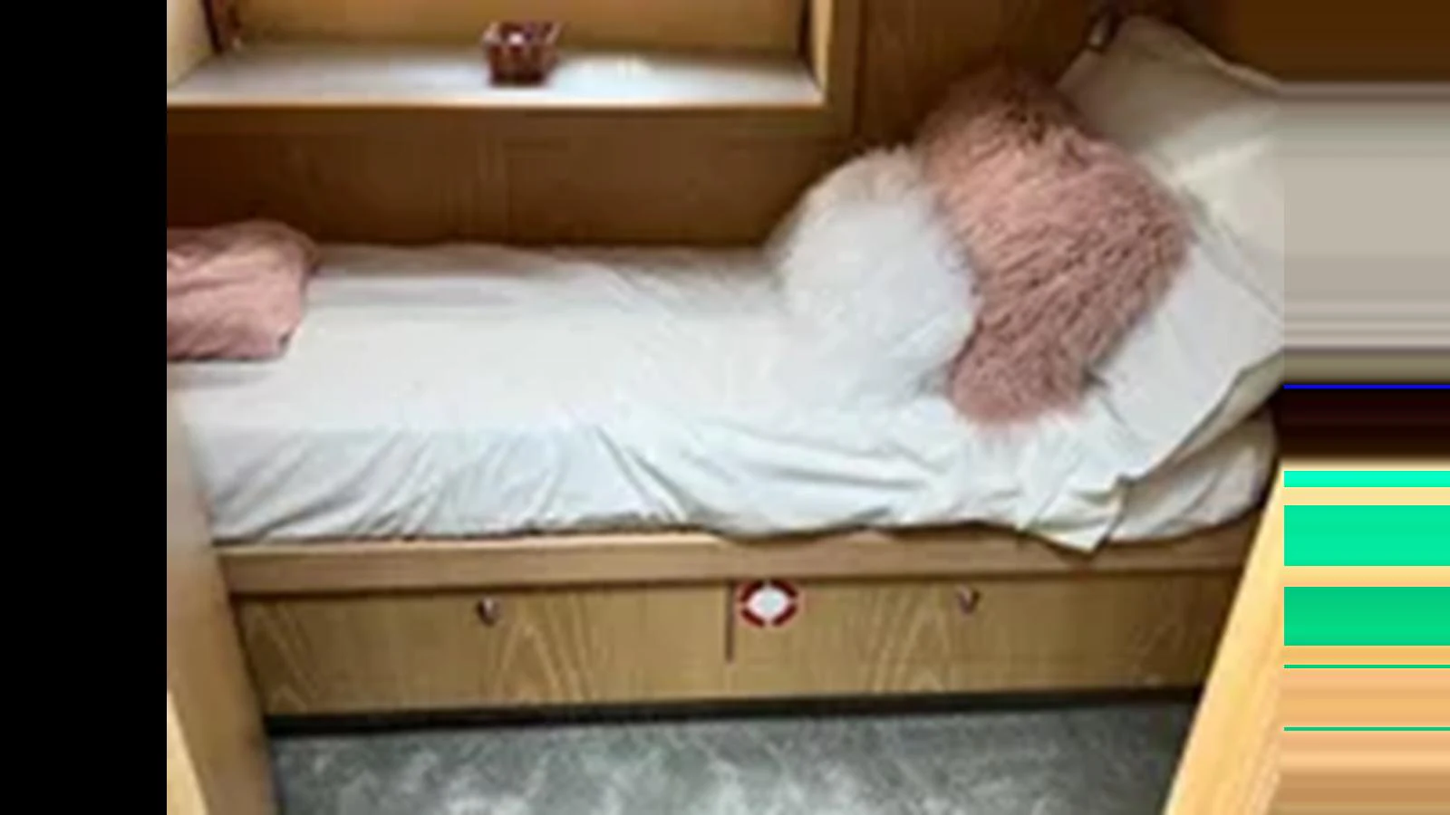 A cozy guest cabin featuring a single bed with plush pillows and wooden cabinetry. aboard 2006 SUNSEEKER PREDATOR 82 Yacht for Sale