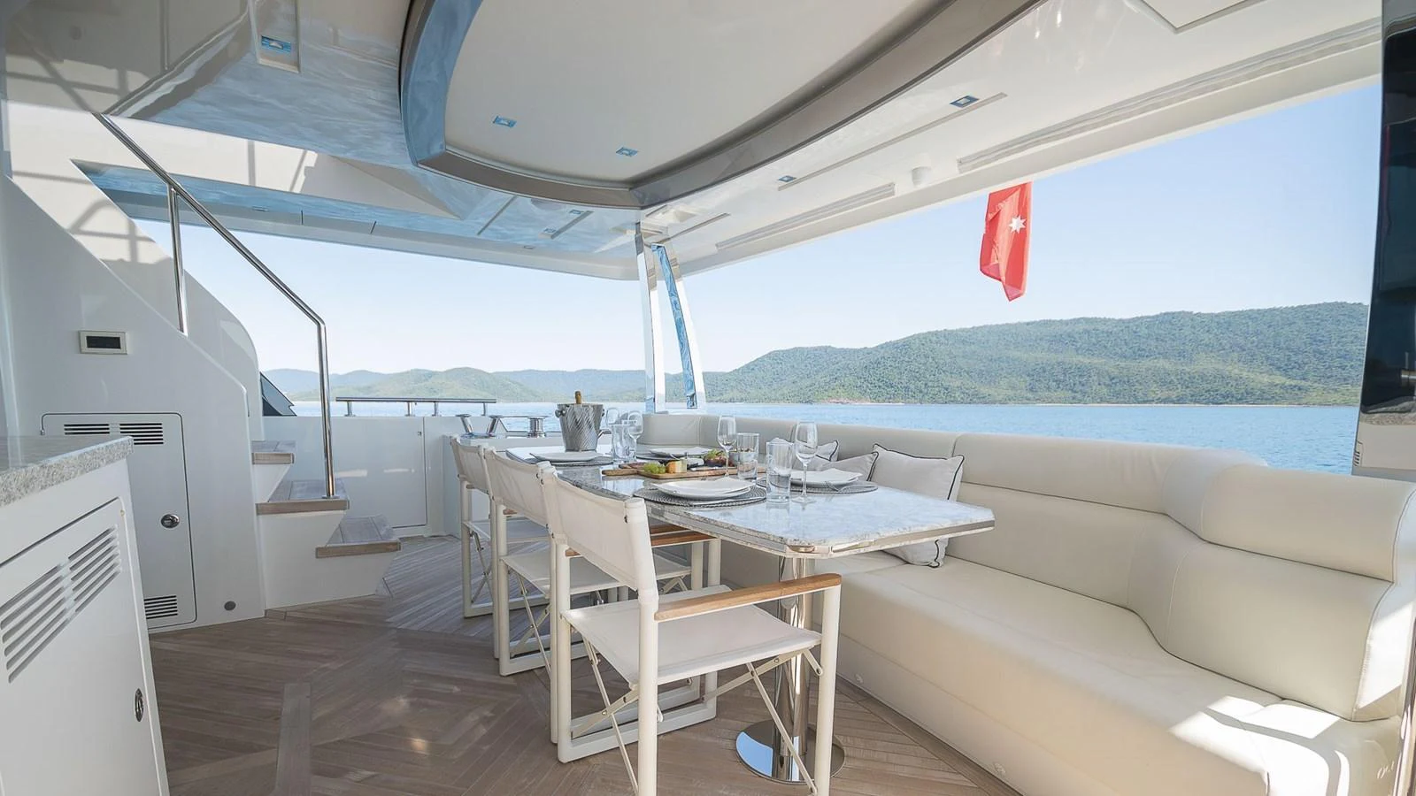 The aft deck features a stylish dining area with a scenic view of the water. aboard MAKORO Yacht for Sale