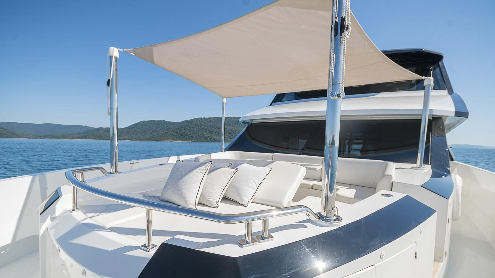 The foredeck features a luxurious sunbathing area with plush cushions and a stylish sunshade. aboard MAKORO Yacht for Sale