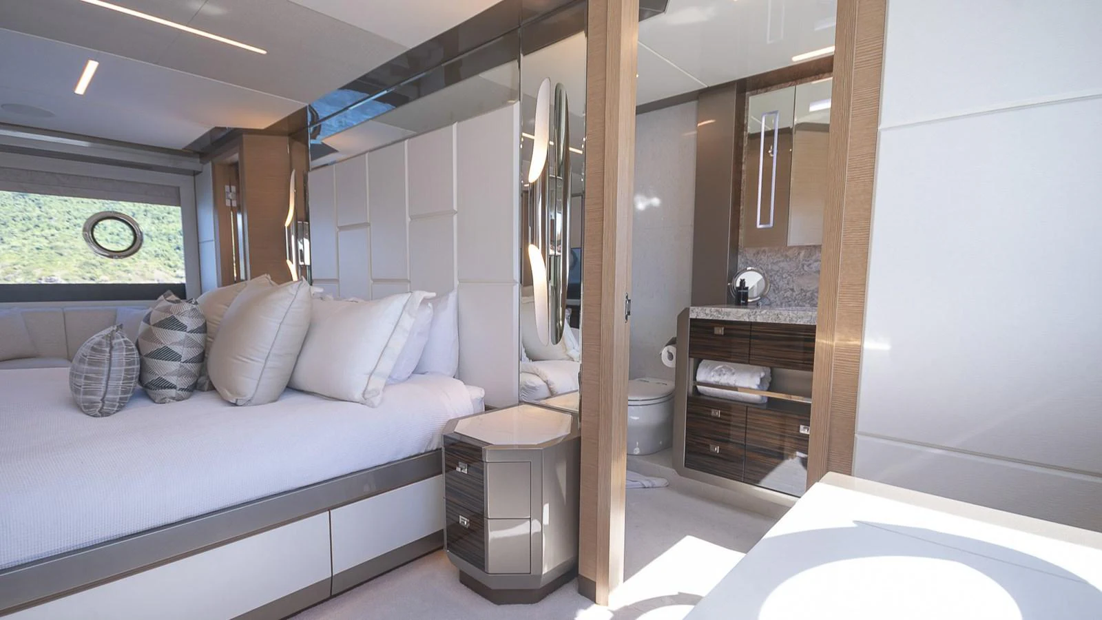 The master stateroom features a luxurious bed with plush pillows and an ensuite bathroom. aboard MAKORO Yacht for Sale