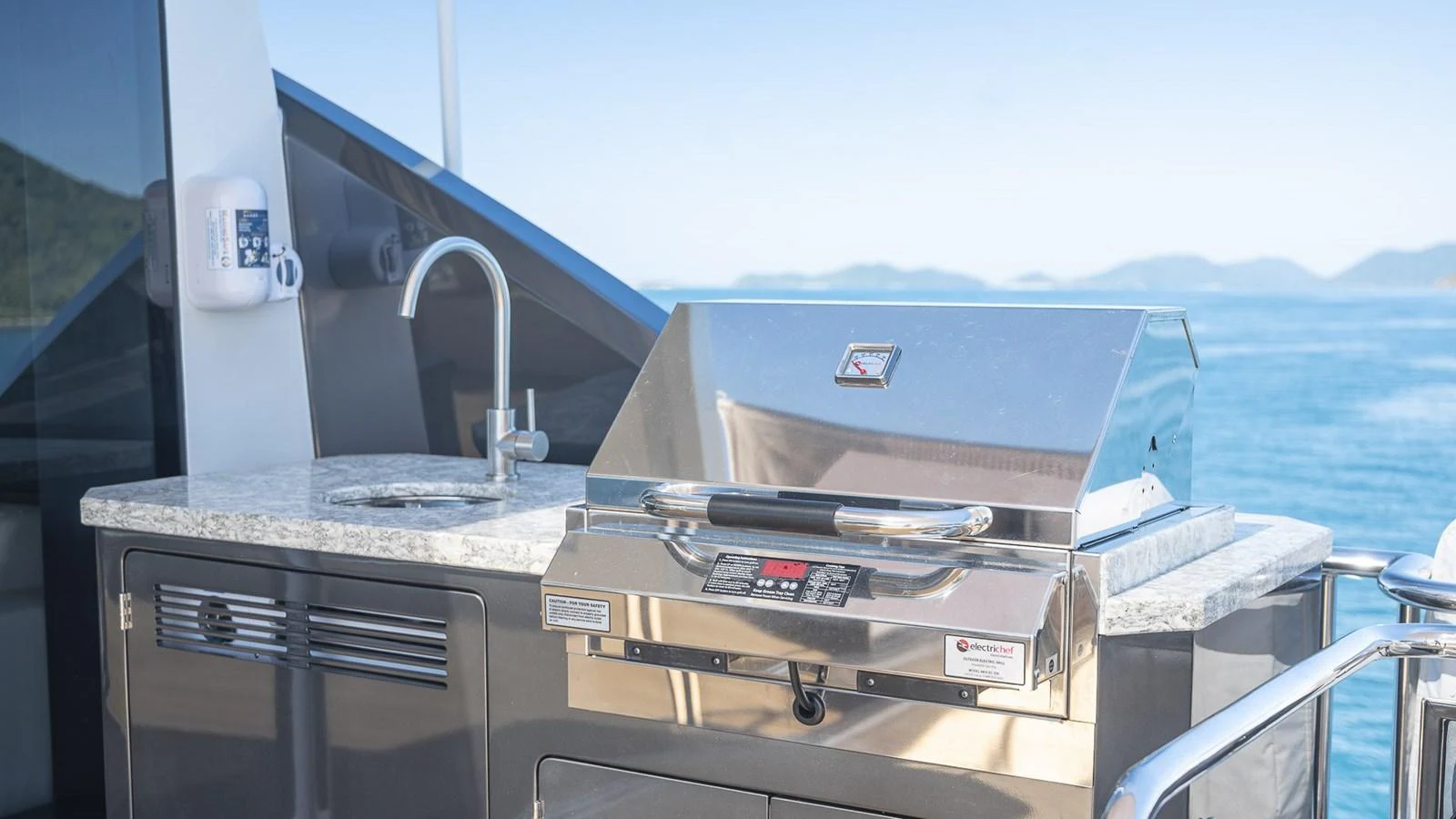 The yacht features a sleek outdoor kitchen with a modern grill and sink, perfect for alfresco dining. aboard MAKORO Yacht for Sale