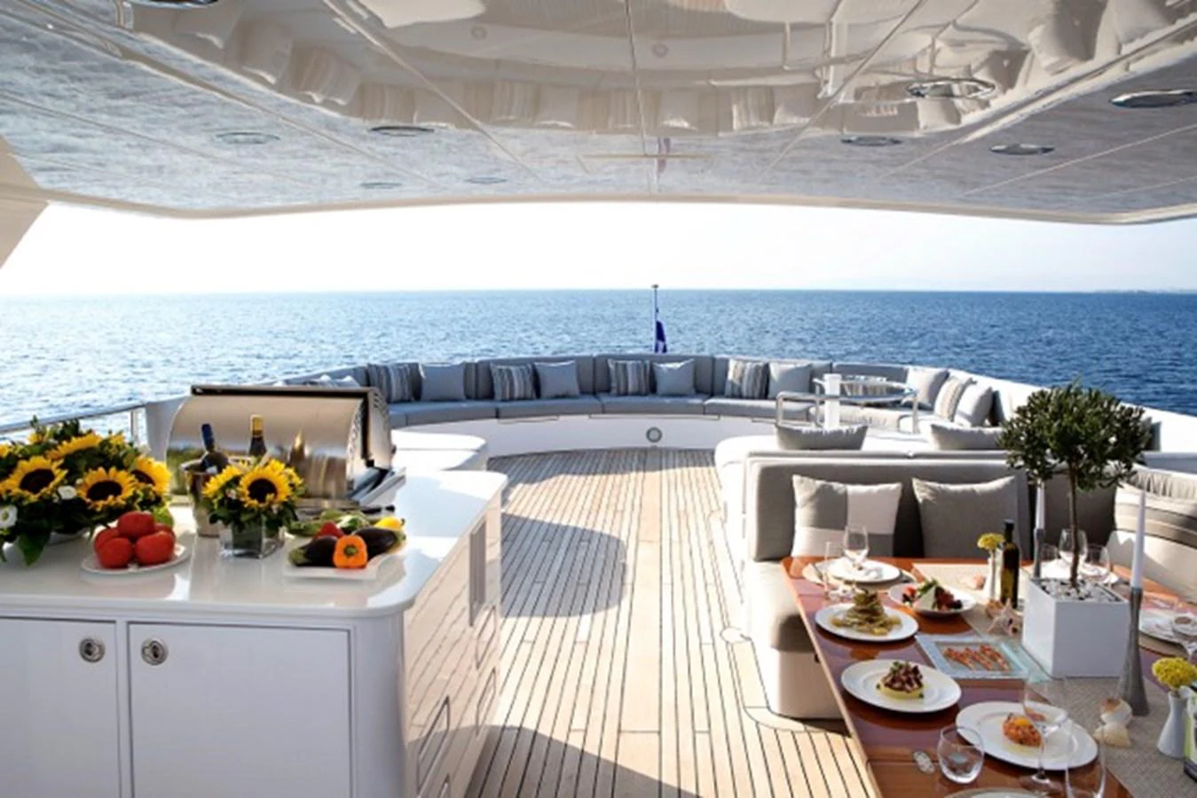 a room with a table chairs and plants on the side aboard MILOS AT SEA Yacht for Sale