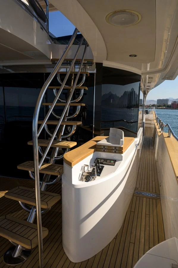 The side deck features a sleek staircase and a well-equipped outdoor bar area. aboard EBRA Yacht for Sale