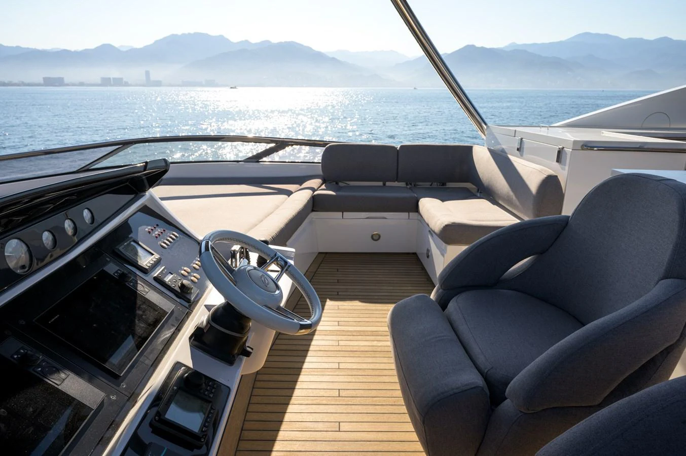The helm area features a sleek control panel and comfortable seating with stunning ocean views. aboard EBRA Yacht for Sale
