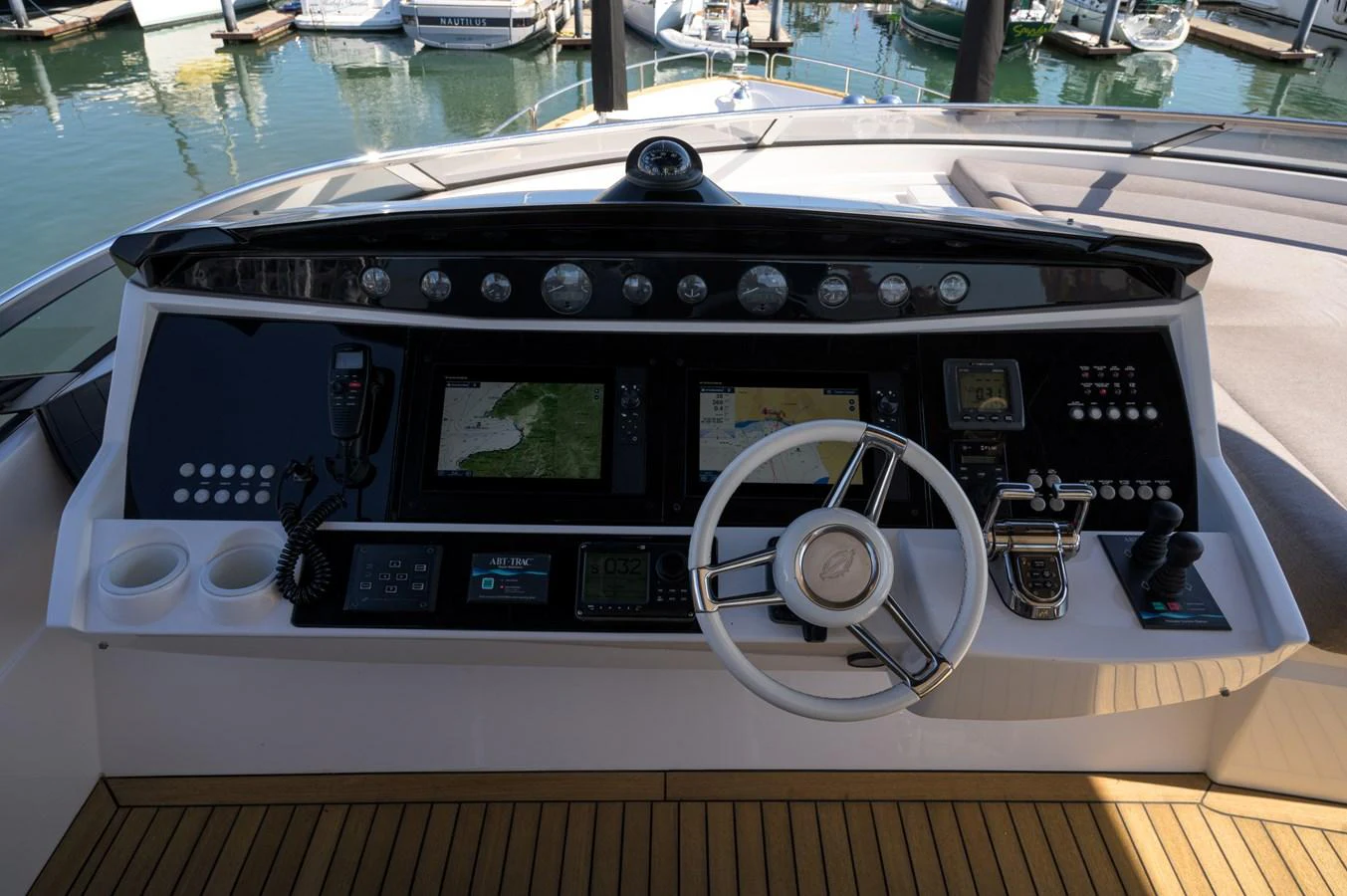 The helm station features advanced navigation equipment and a sleek steering wheel, offering a commanding view of the marina. aboard EBRA Yacht for Sale