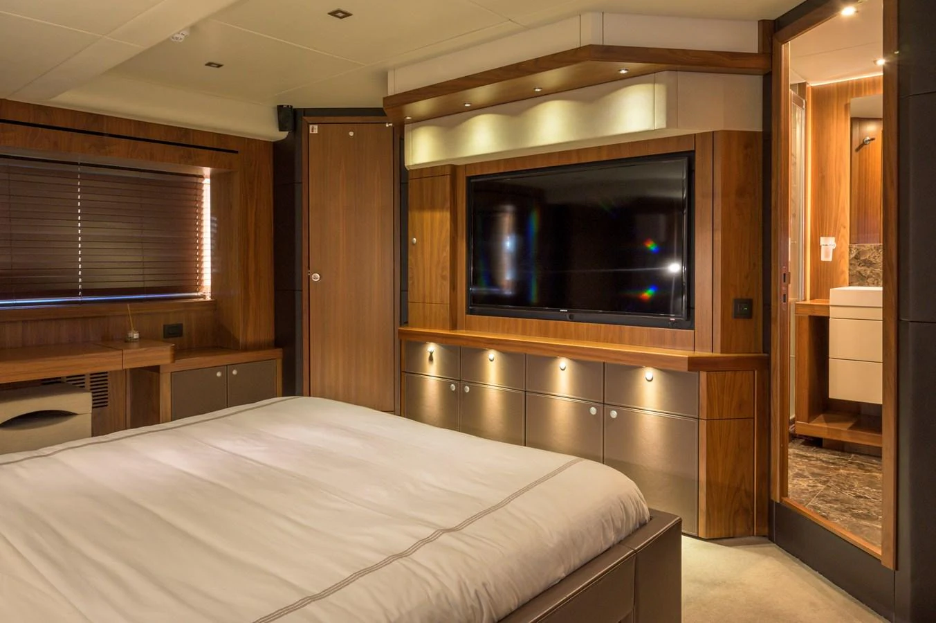 The master stateroom features a luxurious bed, ample storage, and a large flat-screen TV, creating a cozy and elegant retreat. aboard EBRA Yacht for Sale